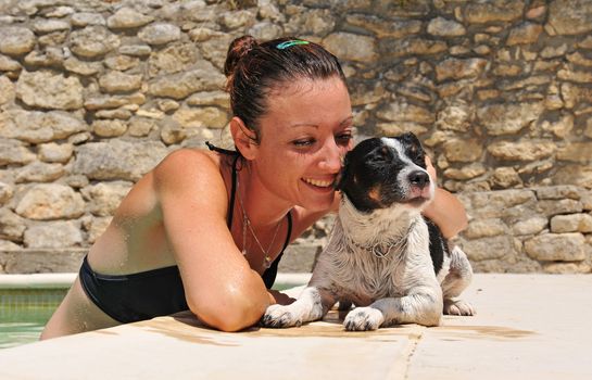 young woman in a swimming pool and her little dog jack russel terrier