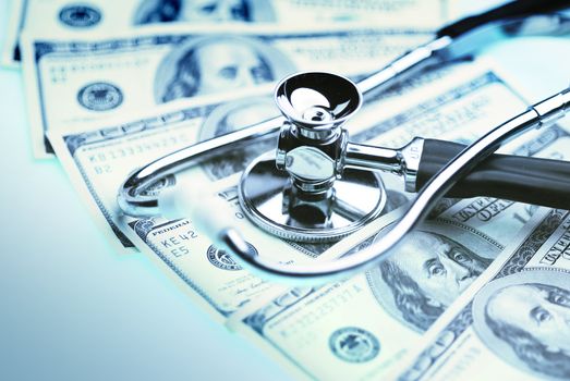 Money and stethoscope to illustrate the cost of health care