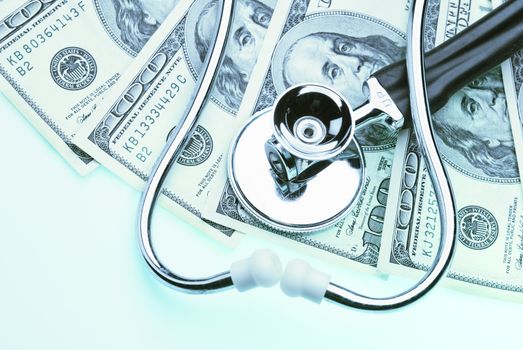 Money and stethoscope to illustrate the cost of health care
