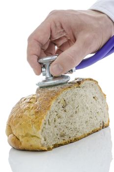 Male hand holding stethoscope on a loaf buckwheat bread with walnuts. Isolated on white background.