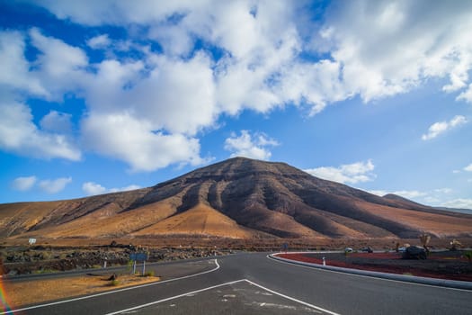 Empty road crossing the lava in the mountain, Lanzarote, Canary islands, Spain