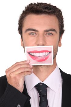 brown-haired young man holding picture of female mouth smiling Dubbroca_Joffrey_160410