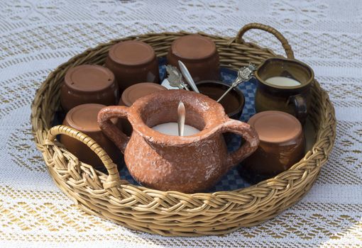 braided basket with tea set on tbale with crochet rug