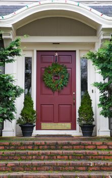 Magenta Door with Wreath on gray home with mossy red brick steps