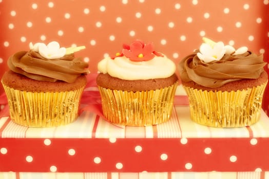 delicious beet and chocolat cupcakes decorated with flowers, in chic polka dots background