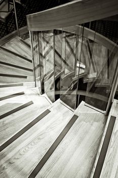 A spiral wooden staircase in monochrome tones