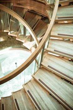 A modern wooden spiral staircase in muted tones