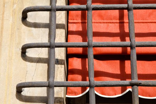 Grate and Window with Red Curtain in Genoa, Italy