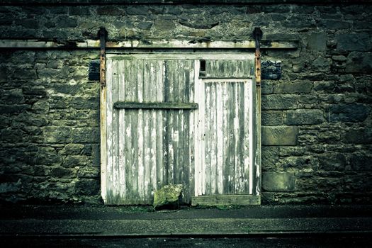 Old weathered wooden door in a wall in muted tones