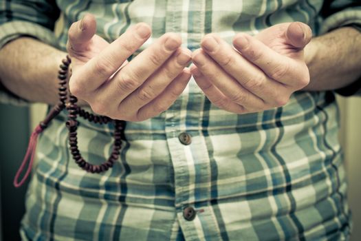 Hands of a young muslim man praying