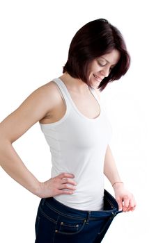 attractive caucasian woman with big jeans on white background, weight loss