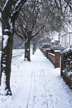 A snow-covered path in a residential area in England