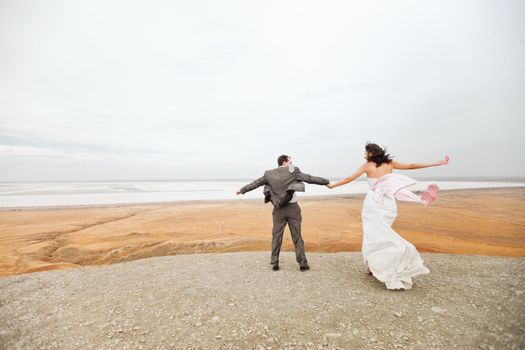 bride and groom on the mountain ready to jump