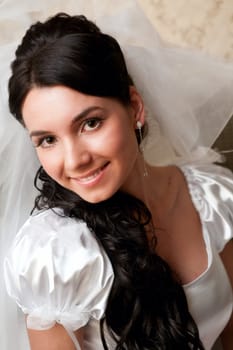 young bride puts on veil on head