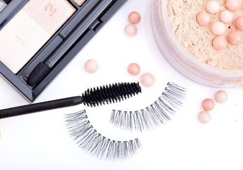 black false eyelashes with mascara and powder, on white background