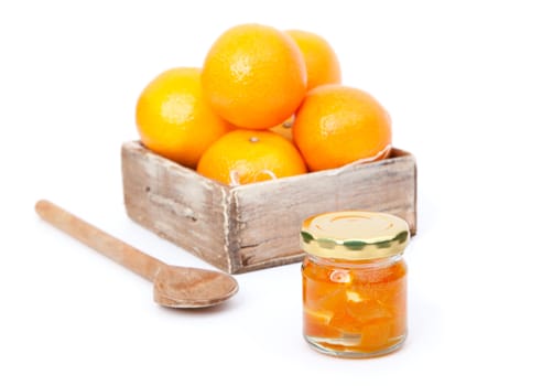 oranges in wooden box with orange jam in the  jar. on white background