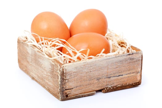 brown eggs at hay, in the old box, on white background
