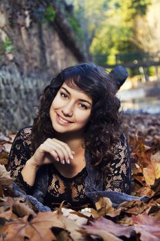 View of a beautiful girl in the middle of autumn leaves.