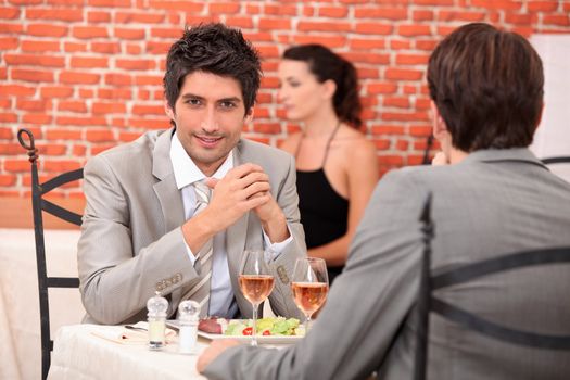 two businessmen eating in a restaurant