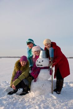 Four happy ladies with snowman