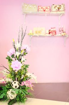 Wedding store background. Artificial flowers and different stuff on glass shelfs