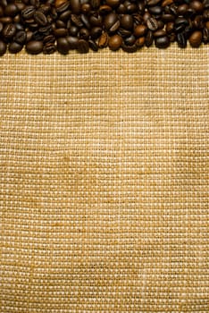 Background of the roasted coffee beans on a burlap piece