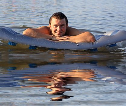 man on the inflatable beach mattress  