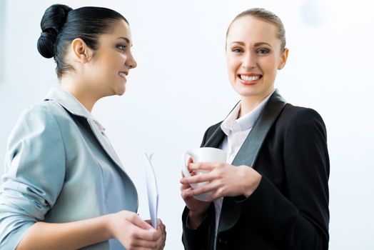 two business women discussing documents in the office