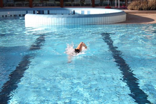 man swims in swimming pool