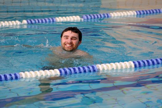 man swims in swimming pool