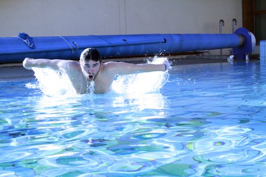 man swims in swimming pool