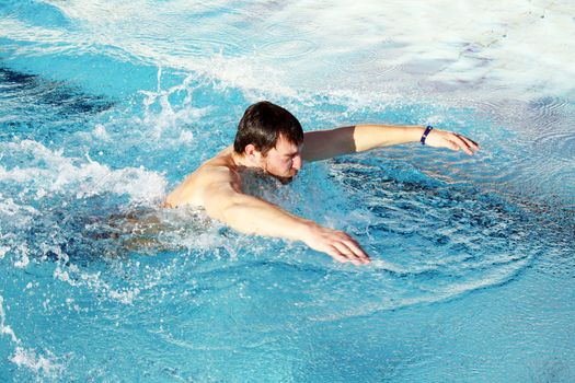 man swims in swimming pool