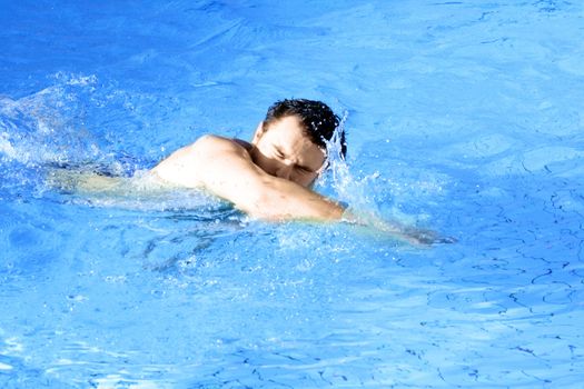 man swims in swimming pool