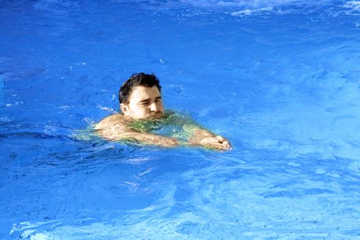 man swims in swimming pool