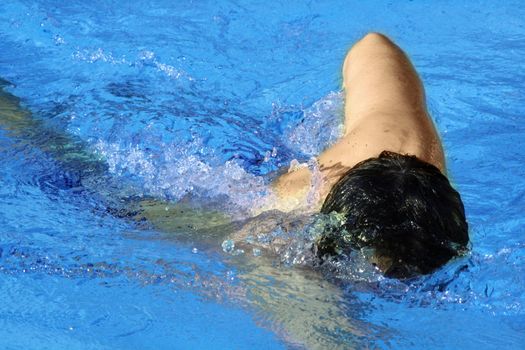 man swims in swimming pool