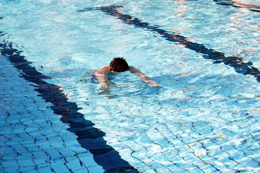 man swims in swimming pool