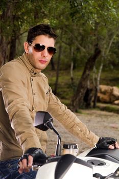 View of a man with a motorcycle on a forest.