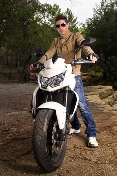 View of a man with a motorcycle on a forest.
