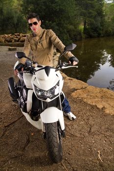 View of a man with a motorcycle on a forest.