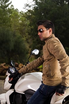View of a man with a motorcycle on a forest.