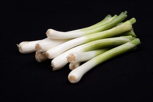 Fresh baby  leek on isolated on a black background