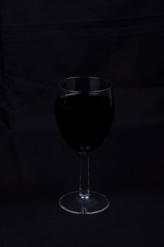 A glass of red wine isolated on black background,