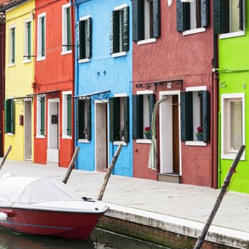 Venice, Burano island canal, small colored houses and the boats