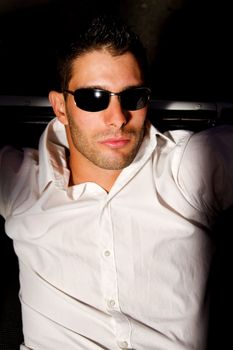 View of a young male next to his white convertible car.