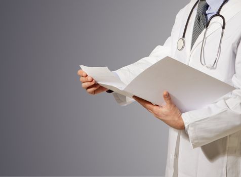 doctor reading clinic folder, isolated on grey background