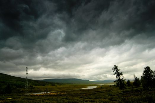 Black stormy sky in the rain in the mountains. Altai. Russia