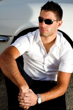 View of a young male next to his white convertible car.