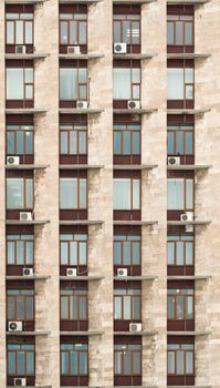 The wall of office building with windows and air conditioners