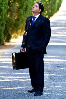 View of a young male business man on a asphalt road.