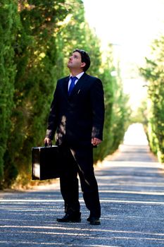 View of a young male business man on a asphalt road.